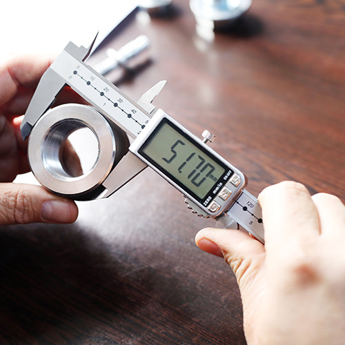 A man is measuring the diameter of a steel fitting from Terranova Steel